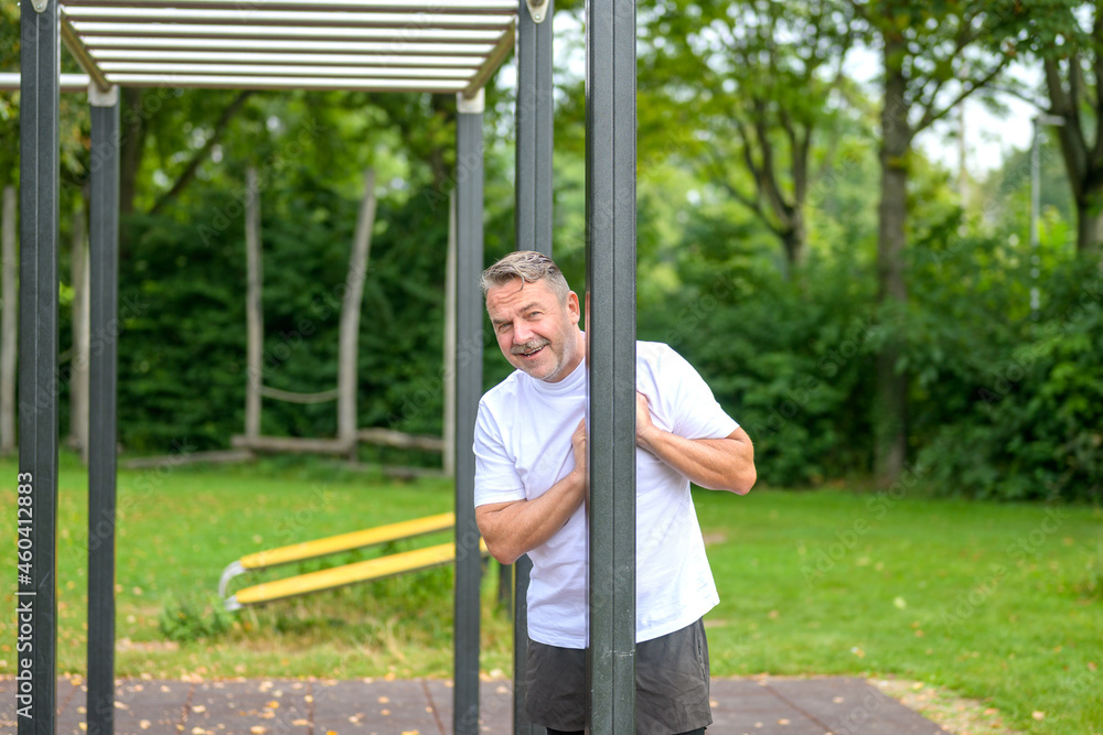 Obraz premium Happy healthy man standing in an outdoors sports area