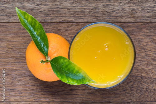 Fresh orange fruit with cut in half slice and green leaf glass of orange juice oisolated on wood background . Top view. Flat lay. photo