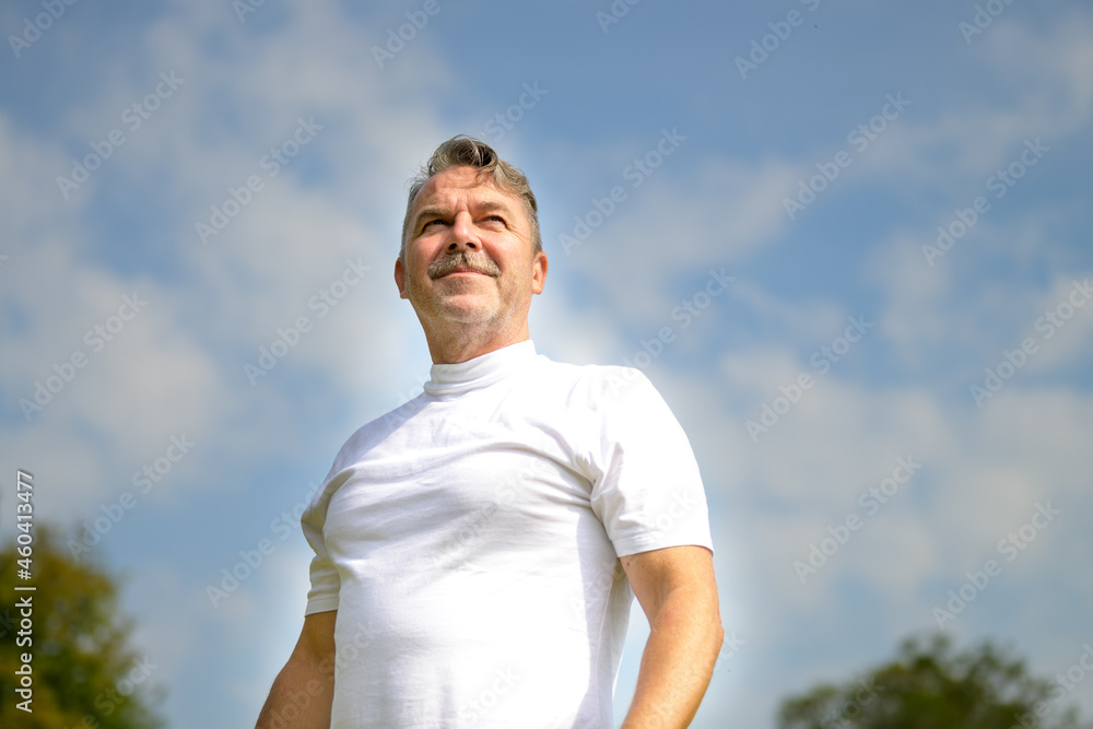 Low angle view against sky of a pensive senior man Low angle view against sky of a pensive senior man