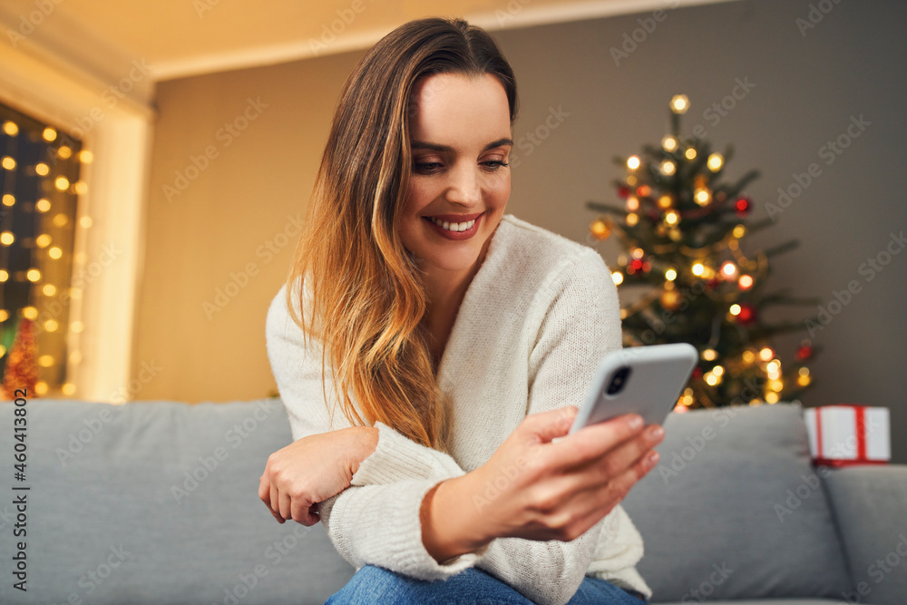Alone woman at home during Christmas using mobile phone Alone woman at home during Christmas using mobile phone