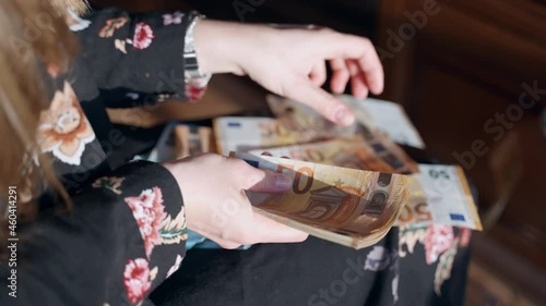Woman hands counting lottery money prize at home and throwing euro banknotes on the floor, person hands holding pack of euro paper currency and counting money cash. Female millionaire checking the photo