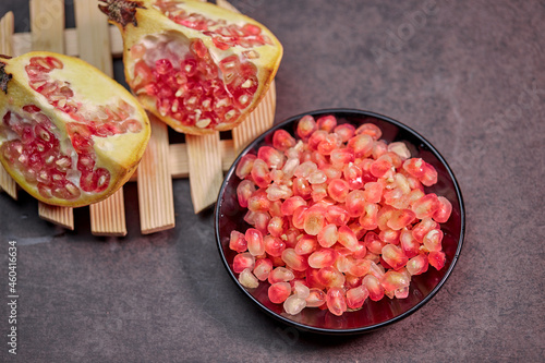 closeup ripe pomegranate fruit and seeds on a plate photo