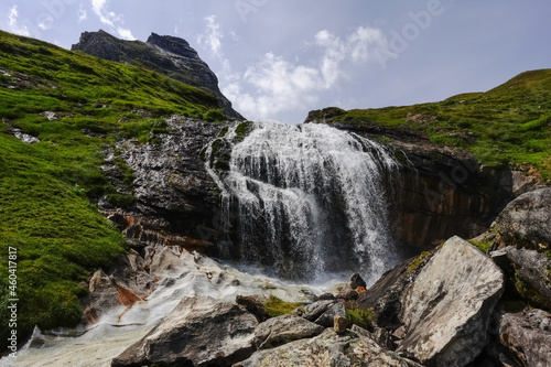gorgeous waterfall over high rocks while hiking to the top of a mountain