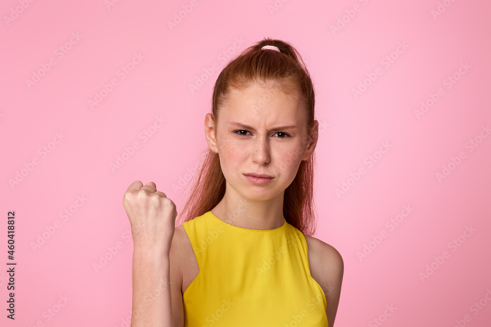 angry teen redhead girl raises hands with excitement, clenches fists angry teen redhead girl raises hands with excitement, clenches fists