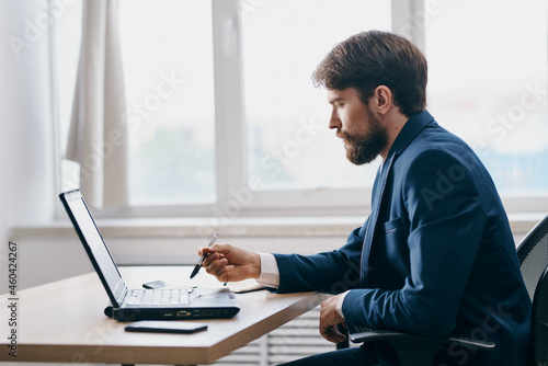 man in front of laptop in the office in front of a laptop executive manager