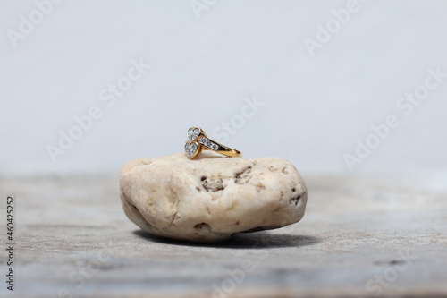 Diamonds with 18k gold rings setting on white rough rock and wood. Fine Jewelry photo set for engagement or wedding ceremony