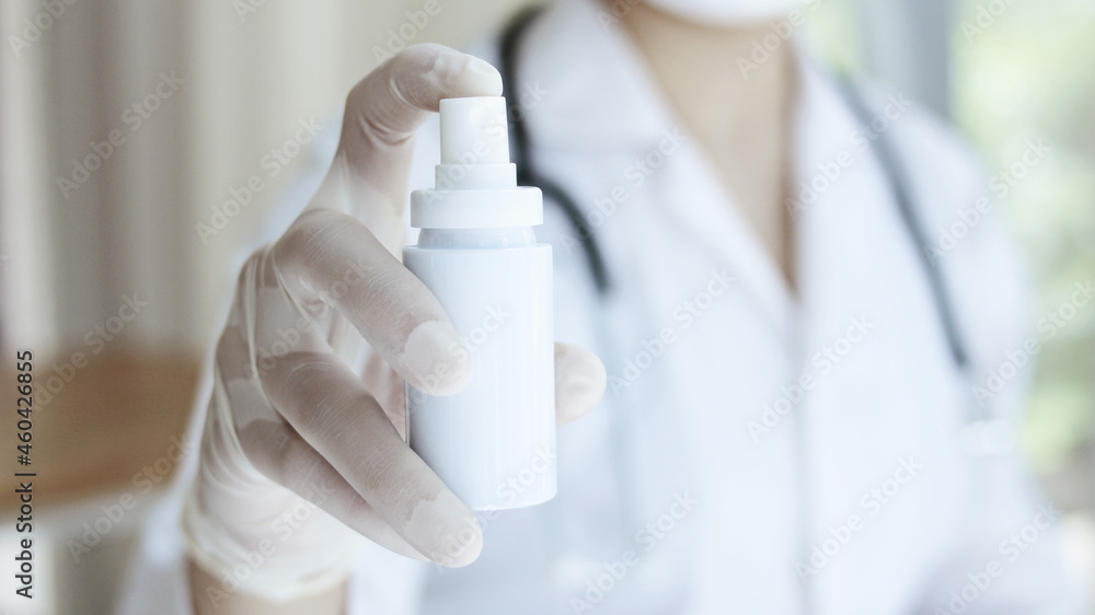 Doctor's hand holding a disinfectant spray bottle covid 19 concept Doctor's hand holding a disinfectant spray bottle covid 19 concept
