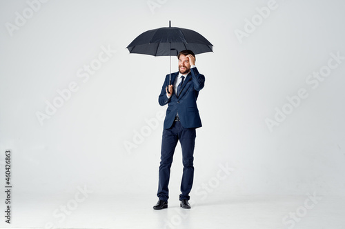 business man in a suit holding an umbrella elegant style rain protection