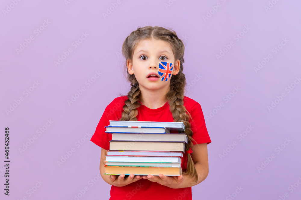 A little girl holds a large stack of books on the English language. A little girl holds a large stack of books on the English language.