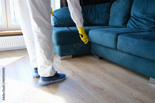 Billede på lærred Person in protective suit and gloves is treating room from painful bacteria