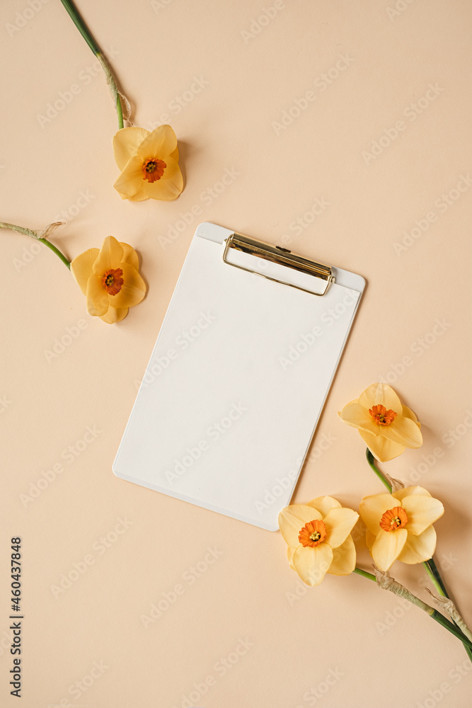 Clipboard tablet pad with blank paper sheet on neutral beige table.  Aesthetic artist home office desk workspace with narcissus flowers. Flat  lay, top view mockup with empty copy space Stock-Foto | Adobe
