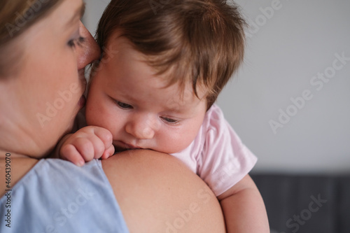 Attractive happy mothers face kiss little baby girl. Happy family