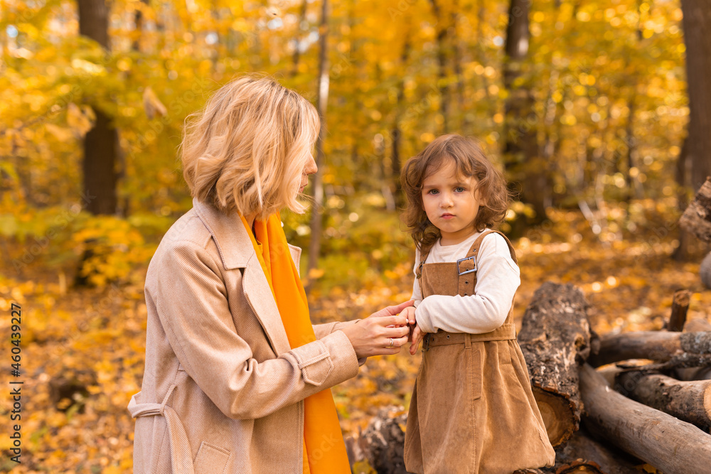 Mother and little daughter enjoying nice autumn day in a park. Season, family and children concept. Mother and little daughter enjoying nice autumn day in a park. Season, family and children concept.