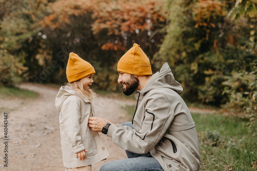 young, stylish bearded father walking with his little daughter in nature at sunset. Family photos of father and one child.