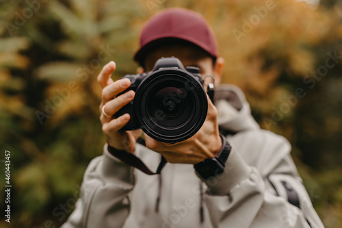 Young Caucasian Male Photographer Taking Picture in the autumn park