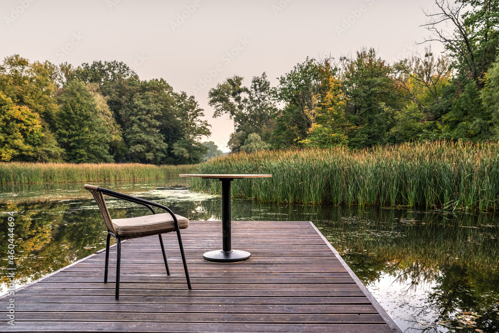 krzesło i stolik na pomoście nad jeziorem jako relaks - obrazy, fototapety, plakaty 