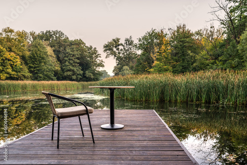 krzesło i stolik na pomoście nad jeziorem jako relaks