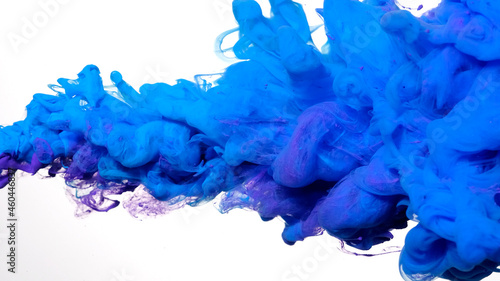 Awesome abstract background. Drops of blue-violet ink in water. Blue and purple watercolor ink in water on a white background. Colored acrylic paints in water.