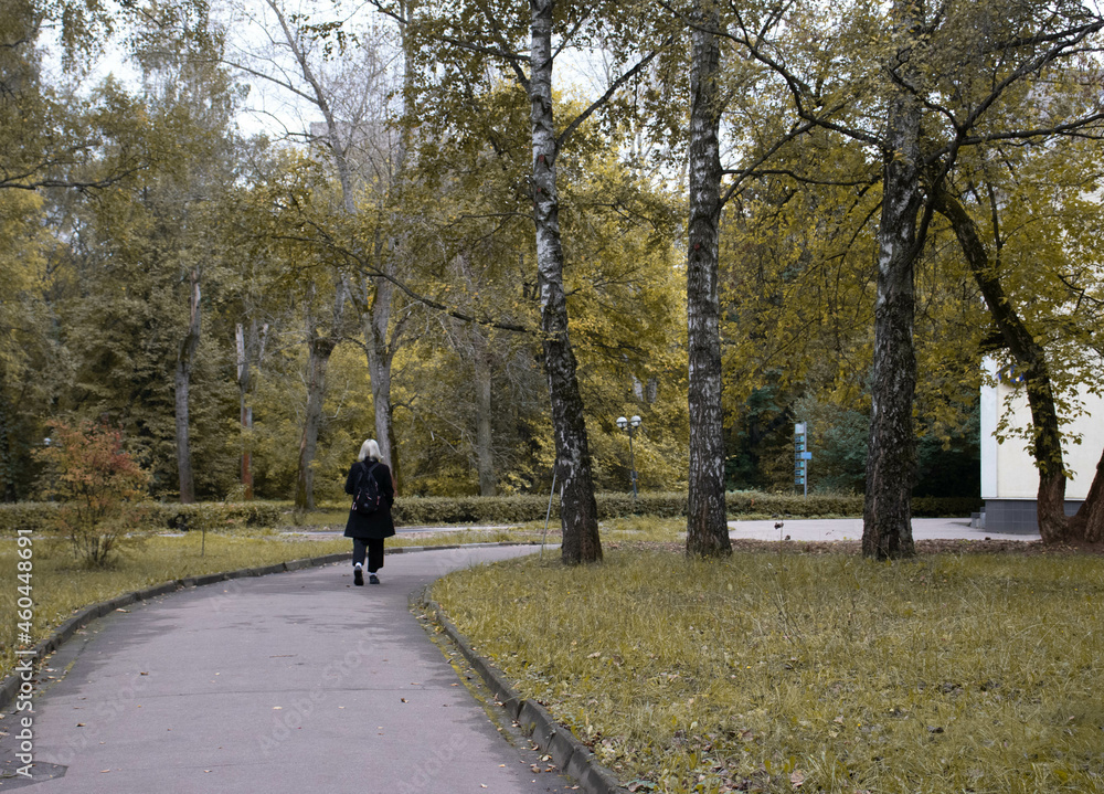 a woman  walking in the park in autumn