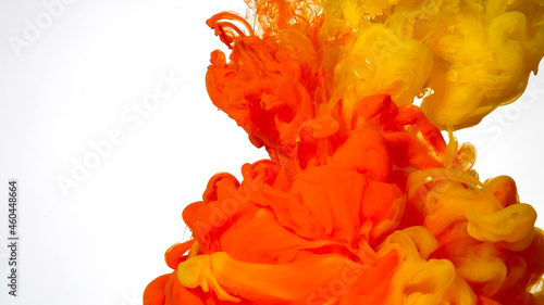 Colored cloud of ink on a white background. Yellow and orange watercolor ink in water on a white background. Abstract background.