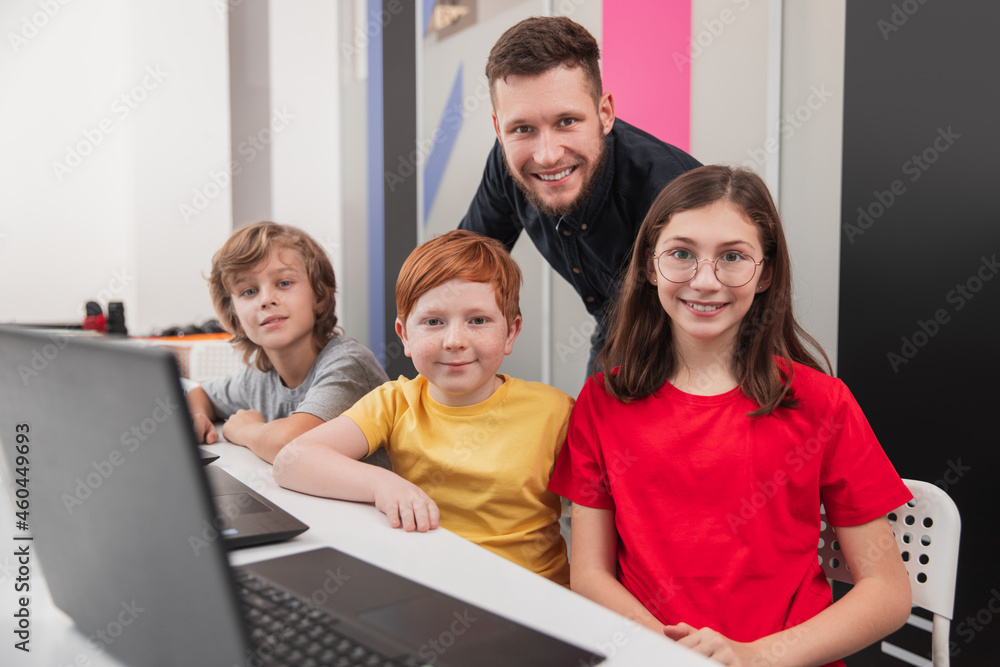 Group of pupils with teacher during computer class Group of pupils with teacher during computer class