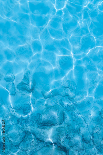 Water background  turquoise shallow sea water. Beautiful texture of sun glare on the water.