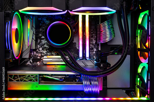 Inside view black high end custom colorful illuminated bright rainbow RGB LED gaming pc. Computer power hardware and technology concept background