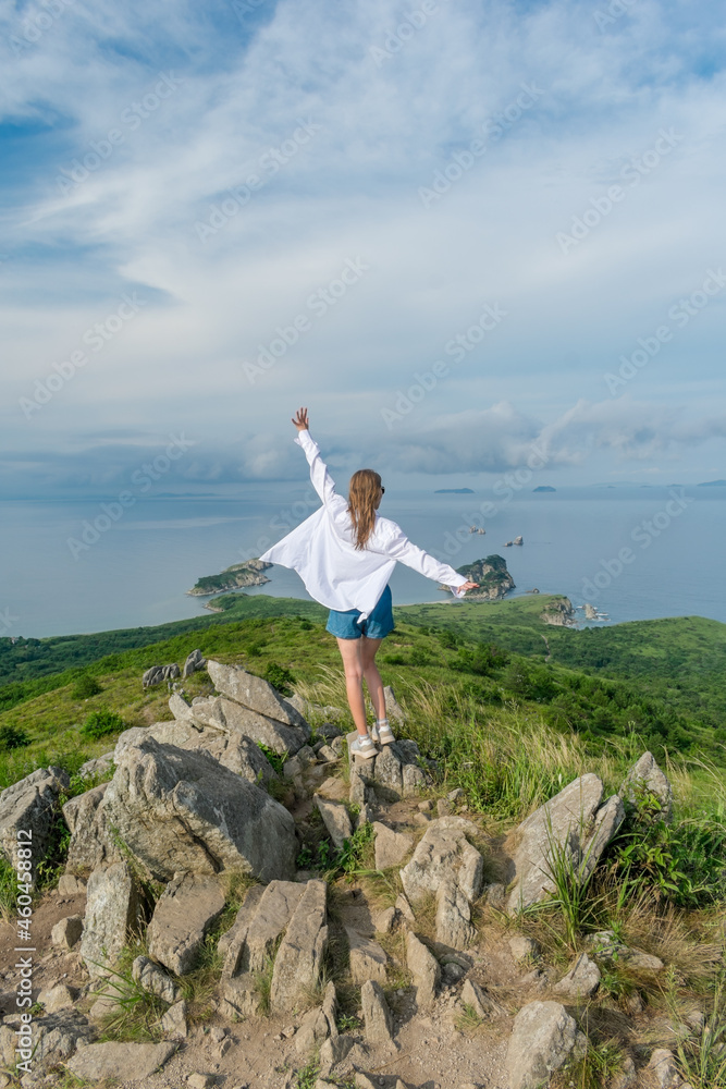 Girl in summer clothes on the top of the mountain near the sea Girl in summer clothes on the top of the mountain near the sea