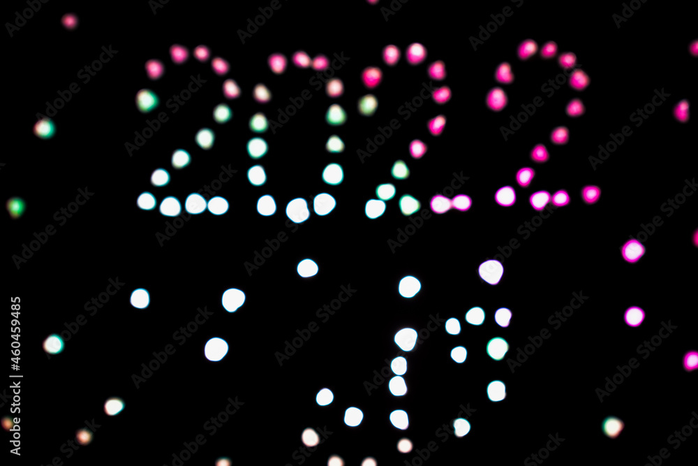2022 lettering made with lights on dark background. bokeh view.