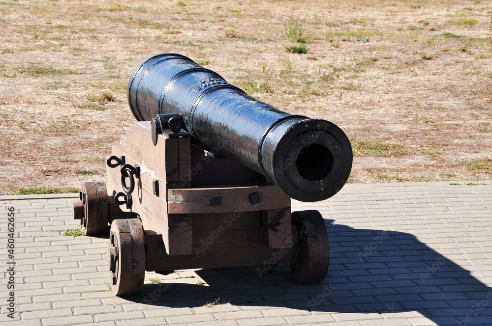 Old cast iron cannon on wooden wheels. A cannon on a wooden gun carriage. Background.