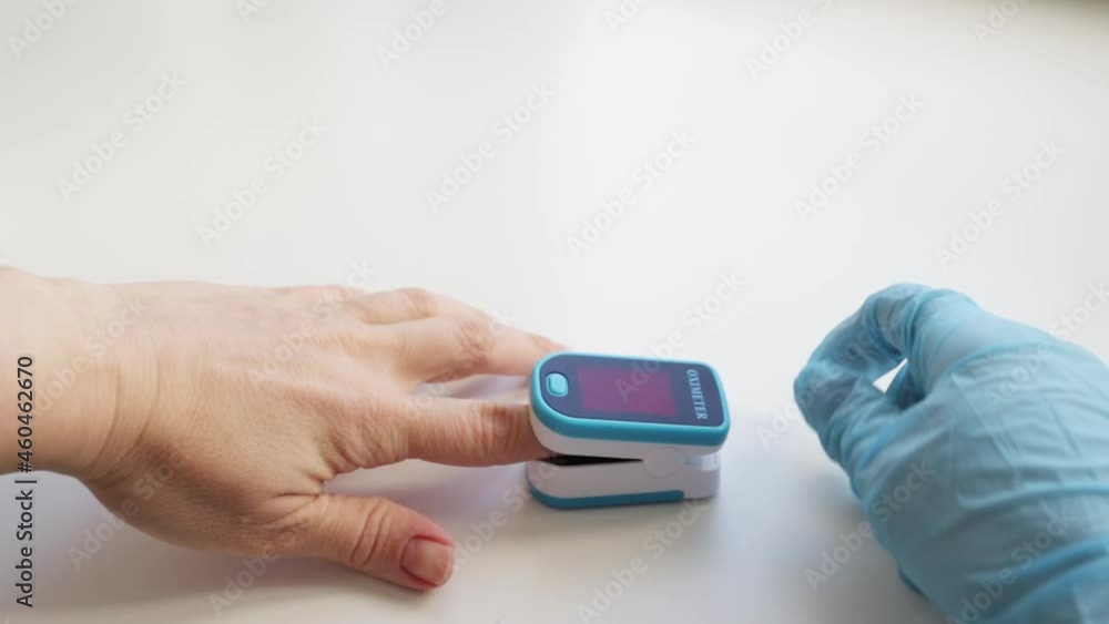 pulse oximeter is a medical device for measuring the level of oxygen saturation of the blood on a woman's finger held by a doctor pulse oximeter is a medical device for measuring the level of oxygen saturation of the blood on a woman's finger held by a doctor