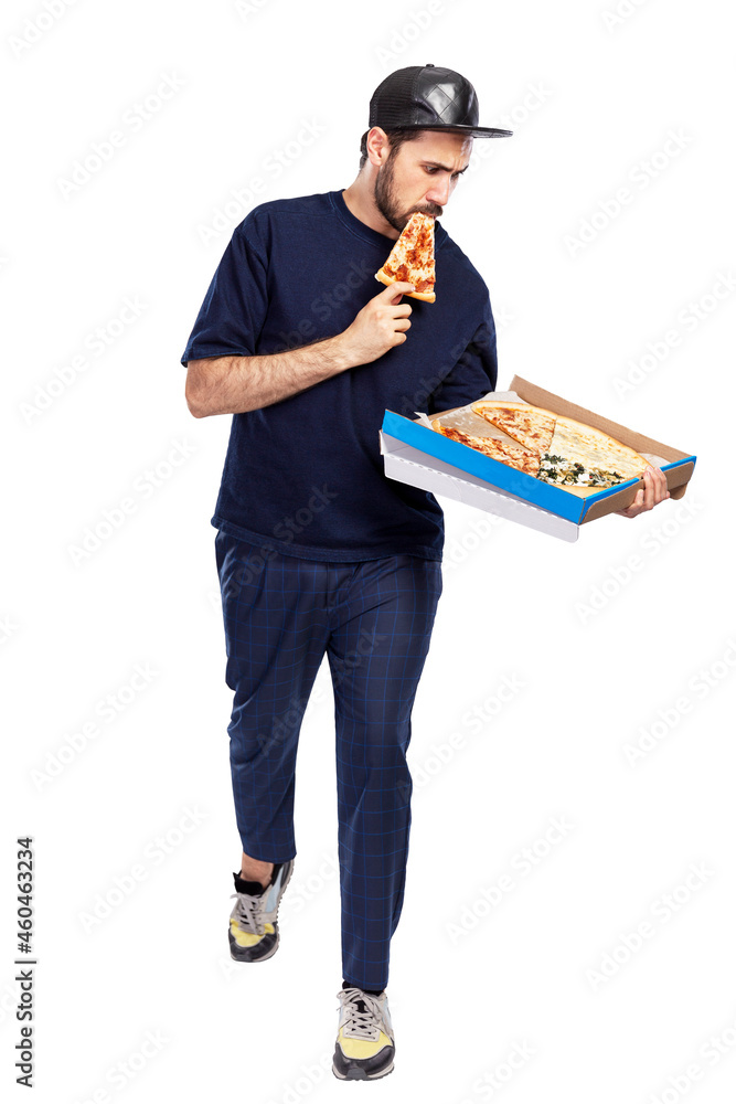 A man with a box of pizza in his hands eats a piece. The guy in the cap and blue clothes. Food delivery. Full height. Isolated on white background. Vertical. A man with a box of pizza in his hands eats a piece. The guy in the cap and blue clothes. Food delivery. Full height. Isolated on white background. Vertical.