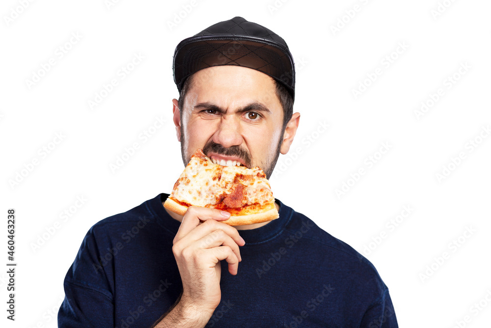 A hungry man in a cap eats a slice of pizza with appetite. Isolated on white background.