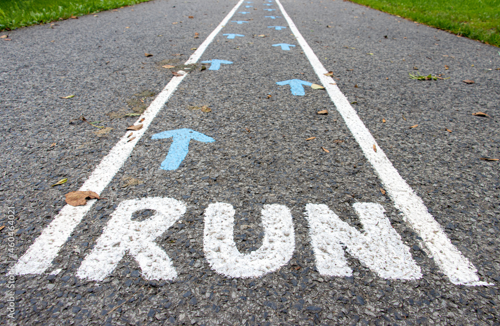 Fototapeta premium A direction arrows with RUN instruction on asphalt road