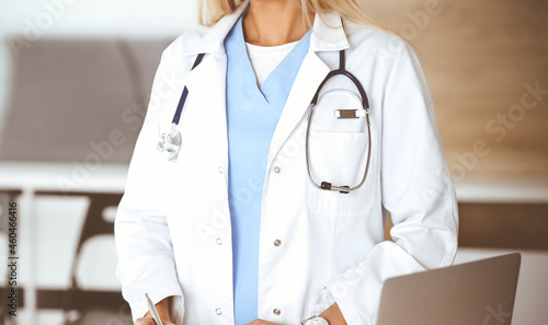 Unknown woman-doctor at work in clinic. Female physician controls medication history record and medical exam results, close-up. Medicine concept