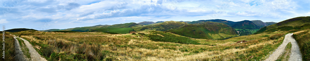 Fototapeta premium Panoramic scene on the black graded Syfydrin mountain biking trail from the Nant yr Arian visitor centre. Taken between Bryn Brith on the right leading to Moel Golomen overlooking Cwm Ty-nant valley.