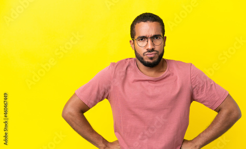 Young latin man isolated on yellow background angry