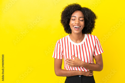 Young African American woman isolated on yellow background smiling a lot