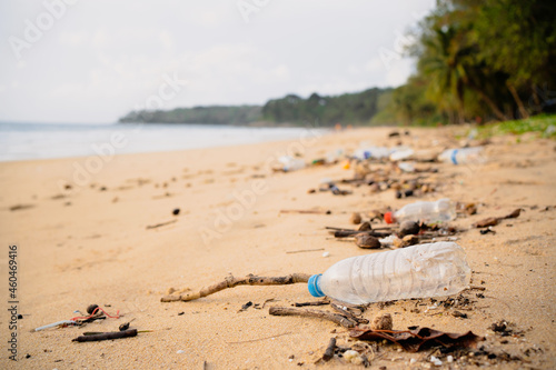 Trash bottles dumped on the sandy beach during the monsoon sea.