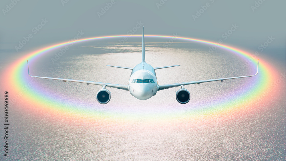 White passenger airplane under the clouds with amazing round shape rainbow - Travel by air transport