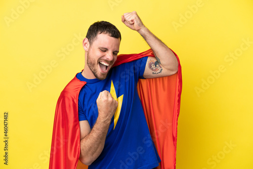 Super Hero Brazilian man isolated on yellow background celebrating a victory