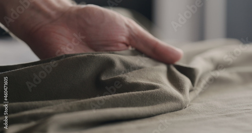 man touching taupe cotton clothes closeup