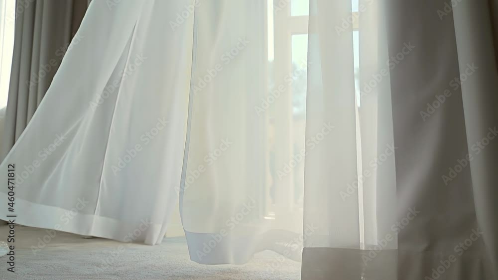 Wind blows the curtain or sways blind in the house or hotel. Sunny day with open balcony or terrace in the room home. Calm quiet morning. The sun shines through the tulle through the window. indoor Wind blows the curtain or sways blind in the house or hotel. Sunny day with open balcony or terrace in the room home. Calm quiet morning. The sun shines through the tulle through the window. indoor