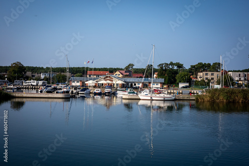 A yacht marina in Dziwnow, Poland.  Sailings boats and harbor buildings, sunny day, blue sky. Background with copyspace. © Kati Lenart