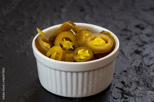 pickled sliced green jalapeno peppers in white bowl