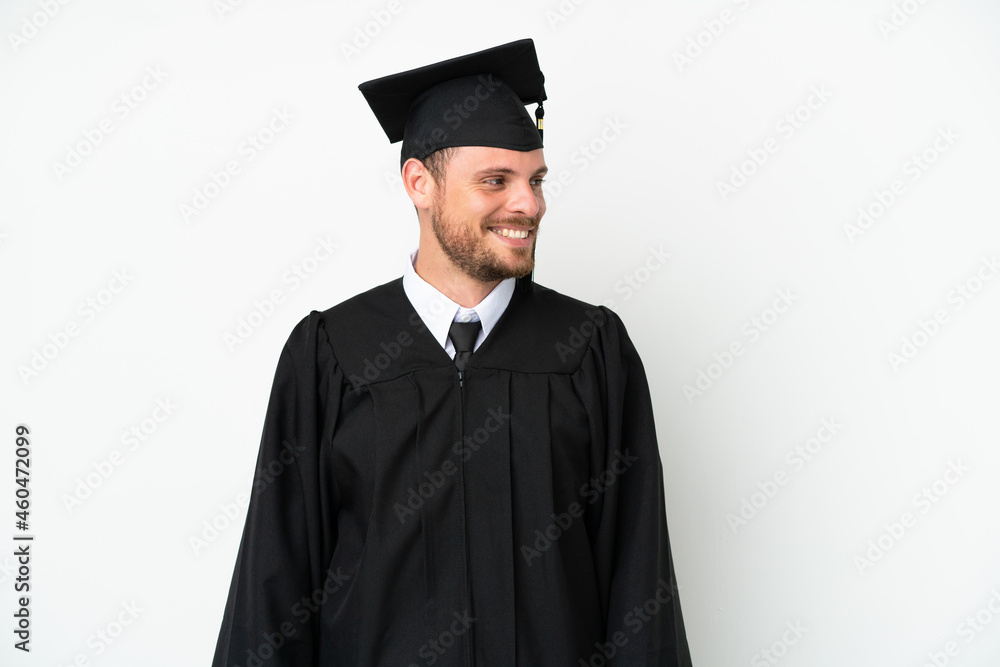 Young university Brazilian graduate isolated on white background looking to the side and smiling Young university Brazilian graduate isolated on white background looking to the side and smiling