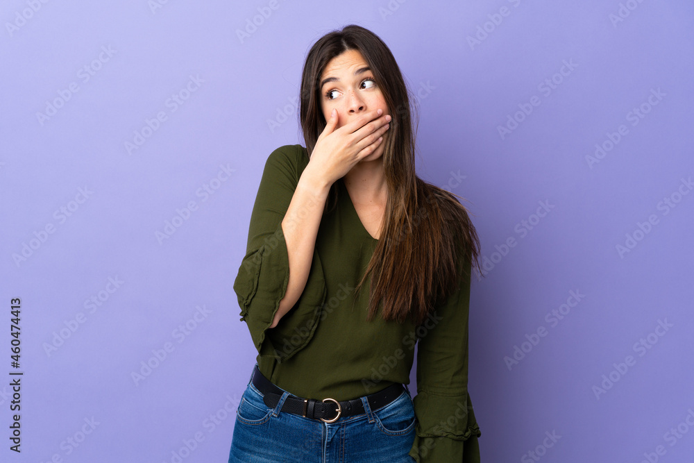 Teenager Brazilian girl over isolated purple background doing surprise gesture while looking to the side Teenager Brazilian girl over isolated purple background doing surprise gesture while looking to the side
