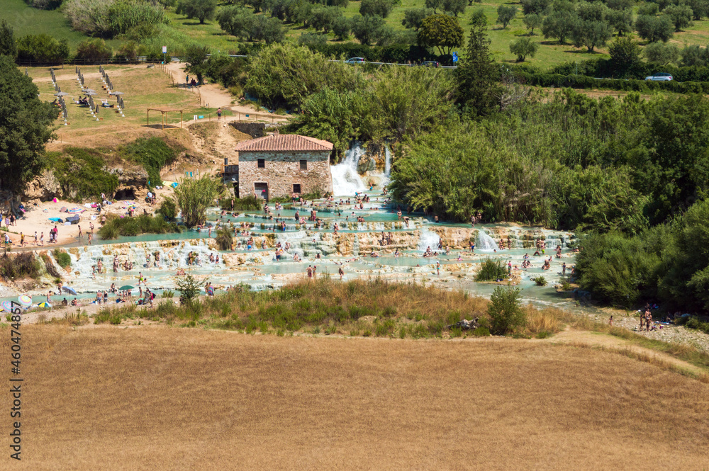 The gorgeous natural thermal bath of Saturnia. Warm water spills out of the rock creating a waterfall with spontaneous ponds, the 