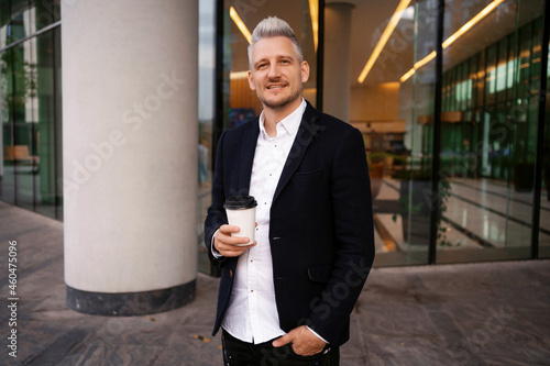 Photography Manager gray drinks coffee on the street near the office in the city center