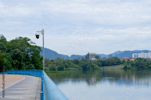 Urban lifestyle cycling road in the public park nearby lake. Greenery scene and clear cloud in the sky in background. 